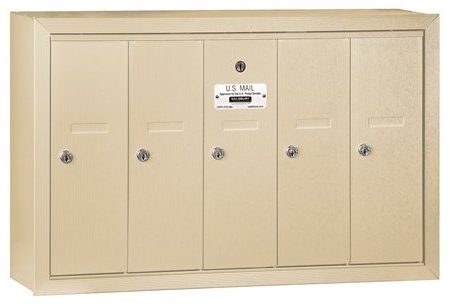 Beige wall-mounted mailbox unit with five locked compartments and a U.S. Mail label.