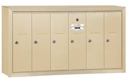 Beige multi-unit wall-mounted mailbox with six compartments and locks.