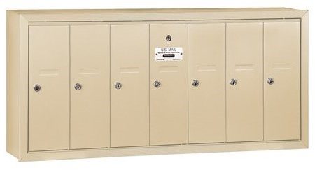 Beige multi-door wall-mounted mailbox with locks and a U.S. Mail label.