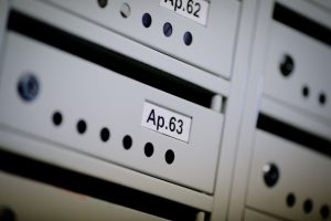 A close up of an apartment number on a mailbox.