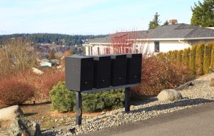 A set of black cluster box units next to a street.