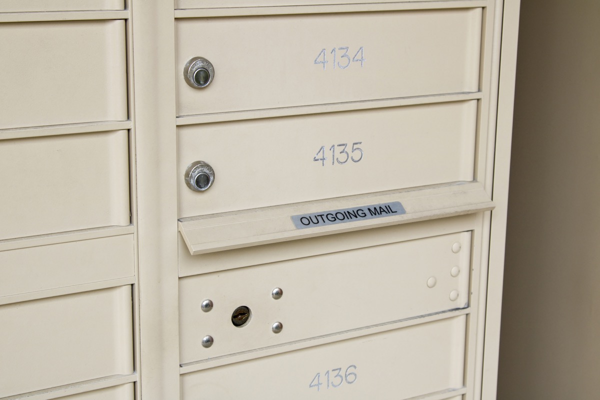 Beige metal mailboxes with locks, labeled 4134, 4135, and 4136, featuring an outgoing mail slot.